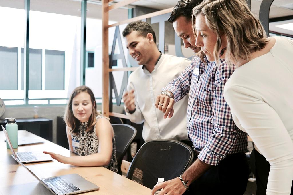 Team collaborating on digital service solutions displayed on multiple devices